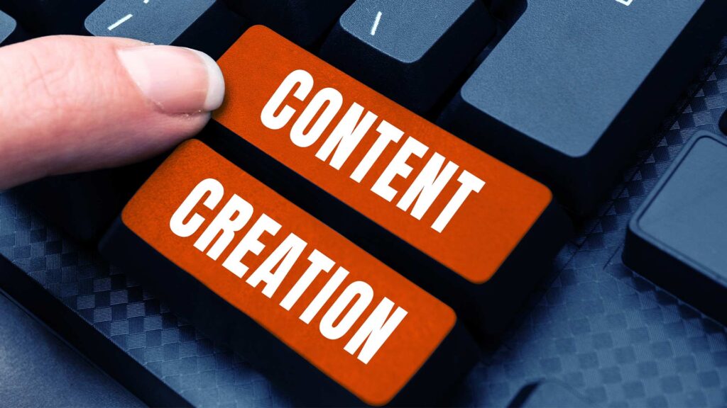The image shows a hand pressing an orange button on a computer keyboard that says "CONTENT CREATION". This represents the concept of social media content creation services, where professionals develop engaging and effective content for brands and businesses to share on their social media platforms.